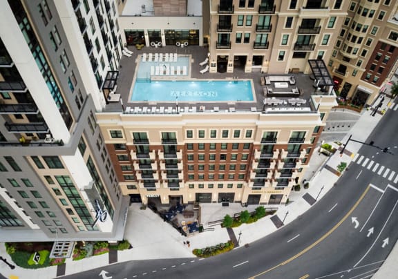 an aerial view of a building with a pool in the middle of a street