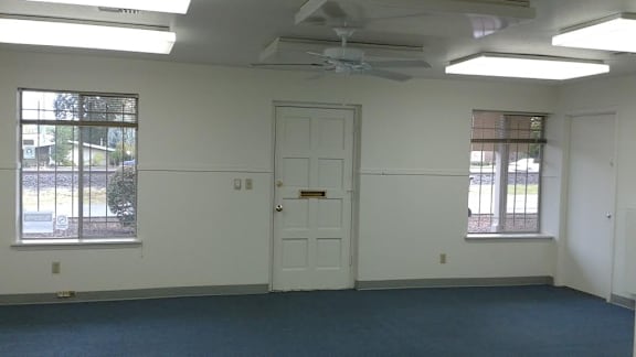 an empty room with a white door and a ceiling fan