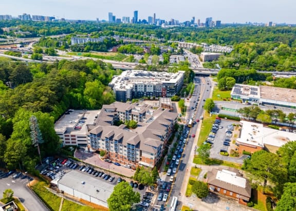 an aerial view of an apartment complex with a city skyline in the background
