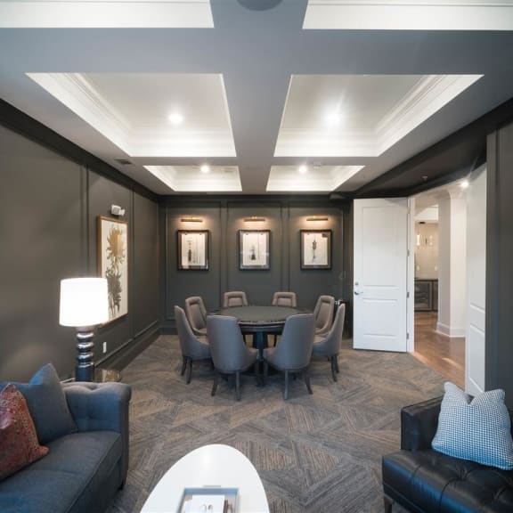Stylish lounge at Tindall Park Apartments featuring dark walls, elegant lighting, and sophisticated seating.