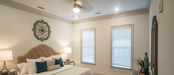 A cozy bedroom with a tufted headboard, neutral bedding, and elegant decor.