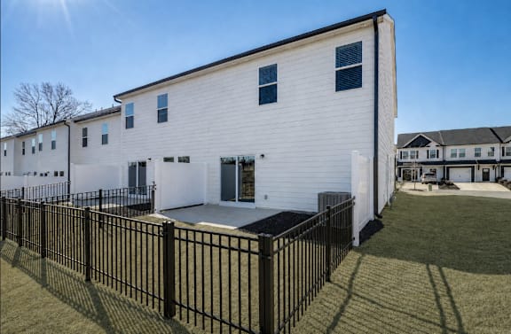 A white building with black railings and a black fence.