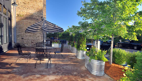 a patio with a table and chairs and a treeat Gaar Scott Historic Lofts, Minneapolis