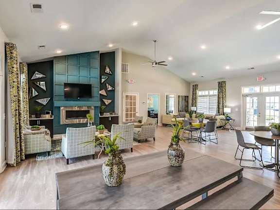 A living room with a grey coffee table and a pineapple vase on it.