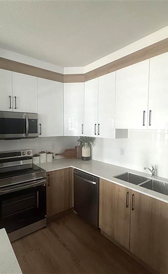 A kitchen with wooden cabinets and a stainless steel oven.at The Pointe at Riverview, Alberta