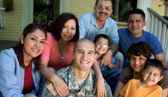 A family of seven sitting on a porch.