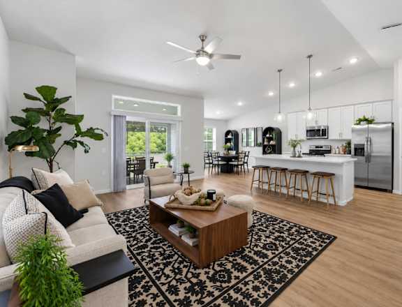 A modern living room with a white sofa, a coffee table, and a ceiling fan.