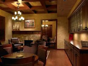 A living room with a stone fireplace and wooden floors.