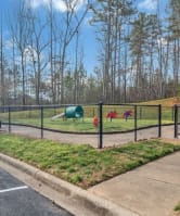 a playground in a park next to a parking lot