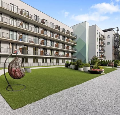 A modern apartment complex with a sculpture in the courtyard.