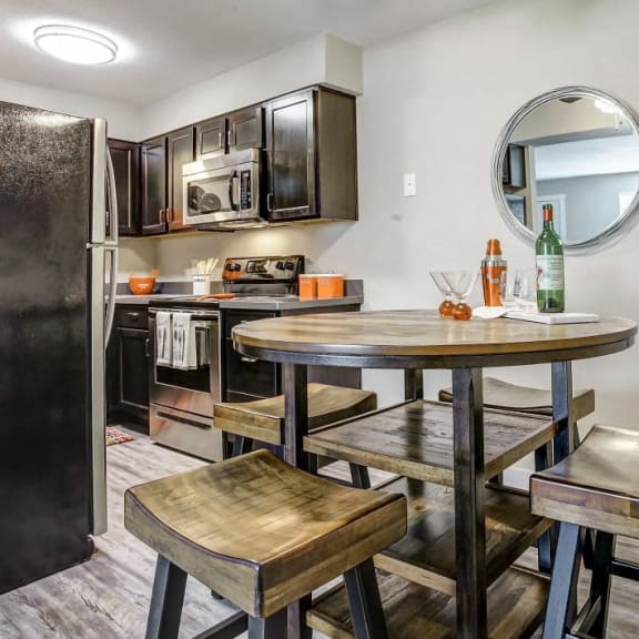 a kitchen with a table and three stools apartments near university of oklahoma