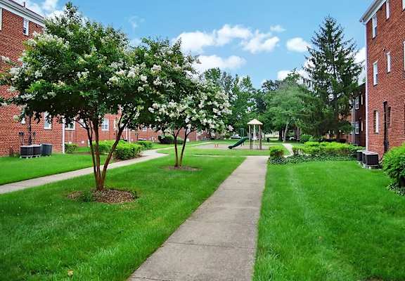 a sidewalk leading to a gazebo in front of a brick building at Parkland Village, Forestville, MD 20747