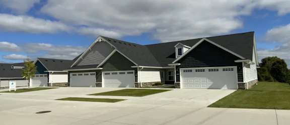 A large house with a grey roof and a white garage door.