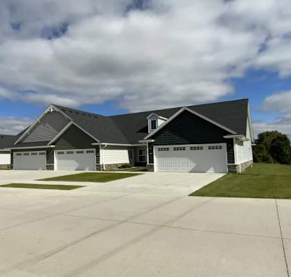 A large house with a grey roof and a white garage door.