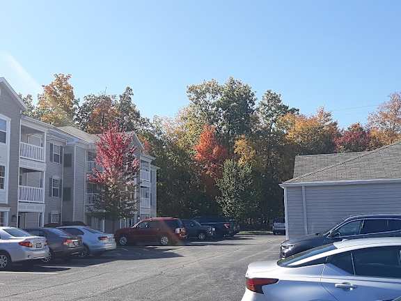 a city street with cars parked in front of apartment buildings