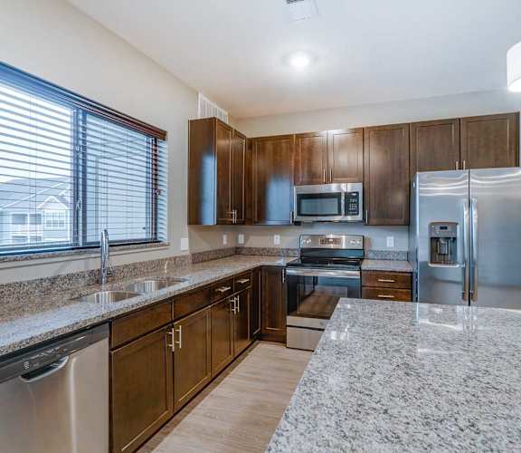 a kitchen with granite counter tops and stainless steel appliances