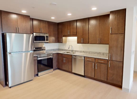 a large kitchen with stainless steel appliances and wooden cabinets