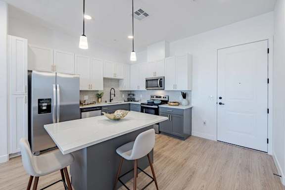A modern kitchen with a white table and chairs.