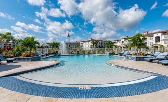 a large pool with chairs and a water fountain