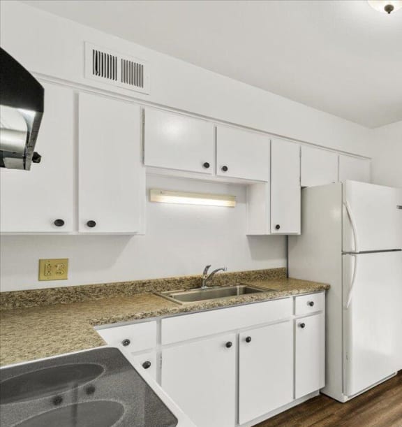 a kitchen with white cabinets and a sliding glass door