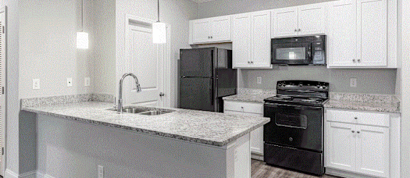 a kitchen with white cabinets and black appliances