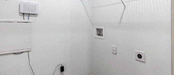 a room with white walls and a white shelf on the wall