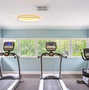 two exercise bikes in a workout room with windows at Polo Clubs Apartments, Austin, TX 78729
