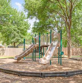 A playground with a slide and a green pole. at Polo Clubs Apartments, Austin, TX 78729