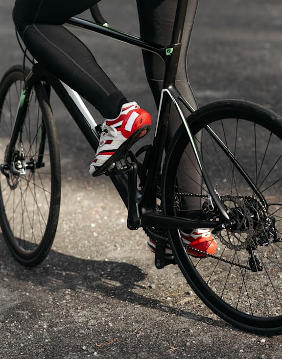 A person is riding a bicycle on a gravel road.