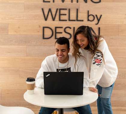 a man and woman sitting at a table looking at a laptop computer  at North Square at The Mill District in North Amherst, MA