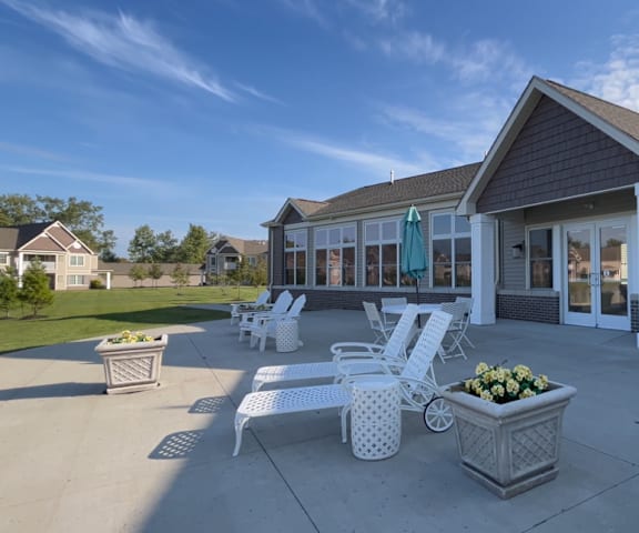 a patio with chairs and tables in front of a building