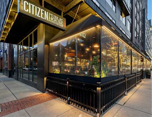A Citizen Public House restaurant with a black awning and lit windows.
