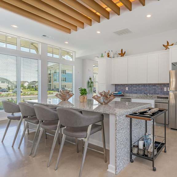 A kitchen with a bar area and white cabinets.