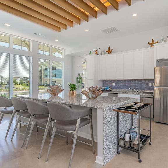 A kitchen with a bar area and white cabinets. at The Banks at Bridgewater Apartments, South Carolina, 29566