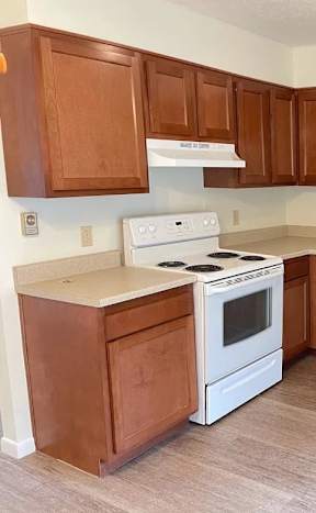A kitchen with a refrigerator, oven, and microwave.