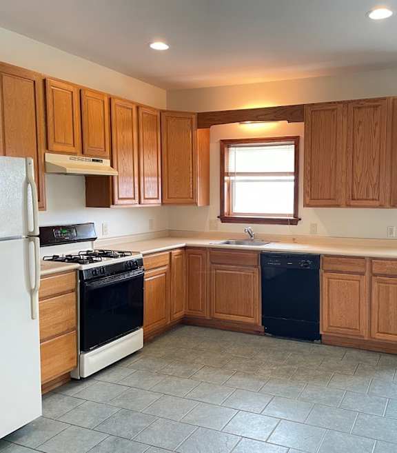A kitchen with wooden cabinets and a white refrigerator.