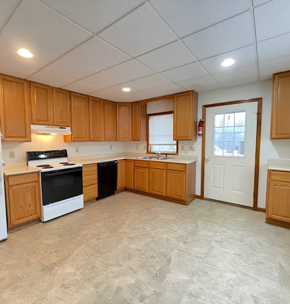 A kitchen with wooden cabinets and a white refrigerator.