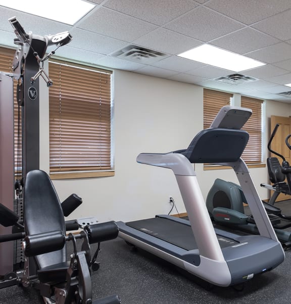 A fitness center with cardio equipment and weight lifting machines at Heritage Park apartments and townhomes in Minneapolis, MN