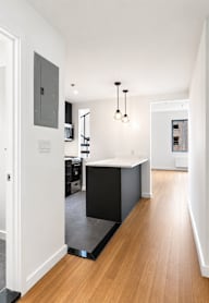 A modern kitchen with a refrigerator, microwave, oven, and sink.