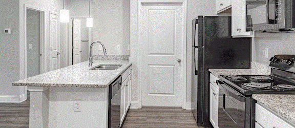 a kitchen with white cabinets and black appliances