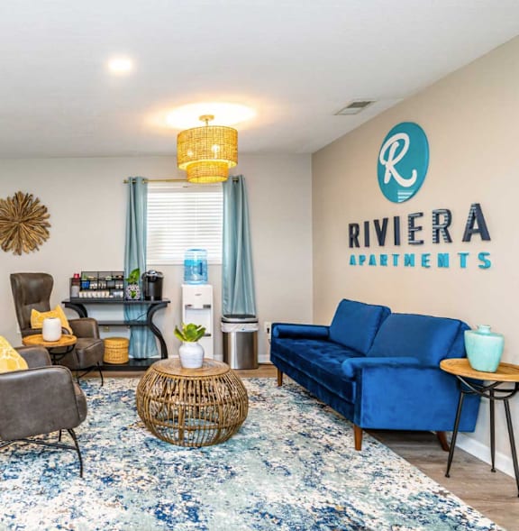 A living room with a fireplace and a blue couch.