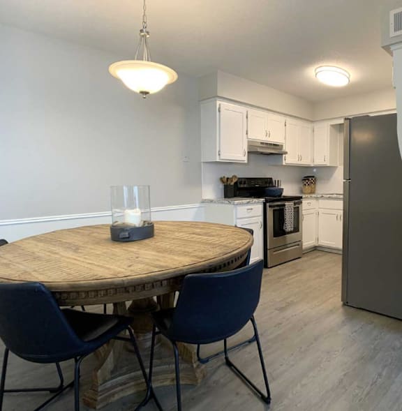 A kitchen with a table and chairs.