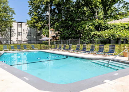 A rectangular swimming pool with a black fence around it.