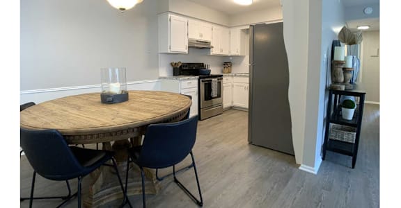 A kitchen with a table and chairs.