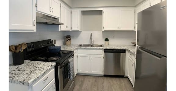 A kitchen with white cabinets and a black stove top oven.