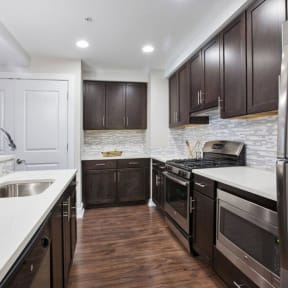 a kitchen with dark cabinets and white countertops