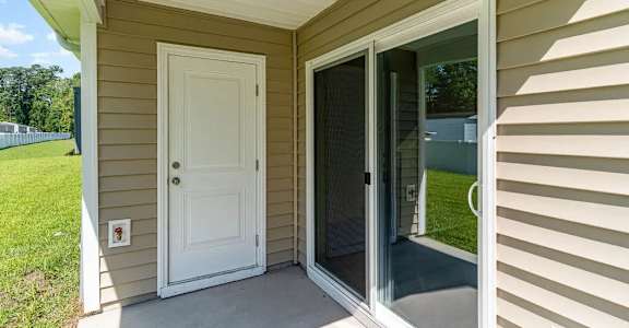 A white door is on the left and a sliding glass door is on the right.