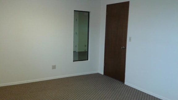 a room with a door and a mirror on the wall