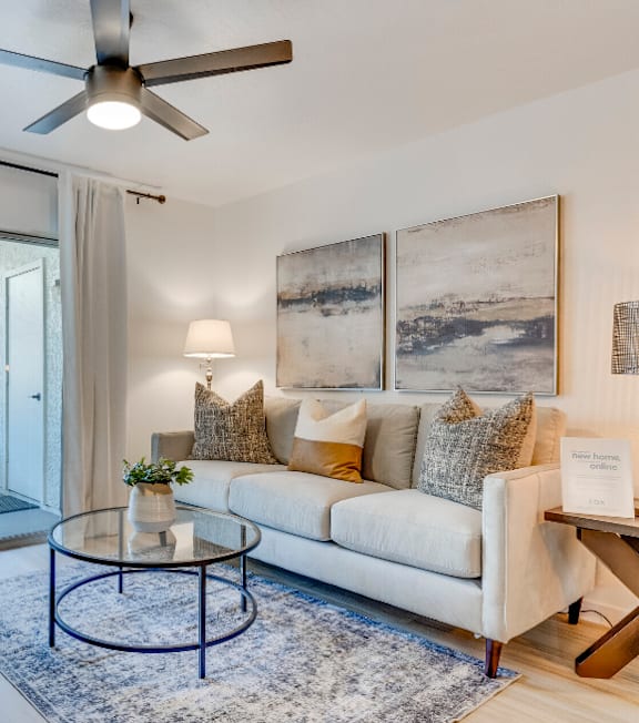 a living room with a ceiling fan and a sliding glass door