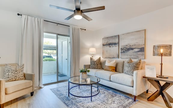 a living room with a ceiling fan and a sliding glass door